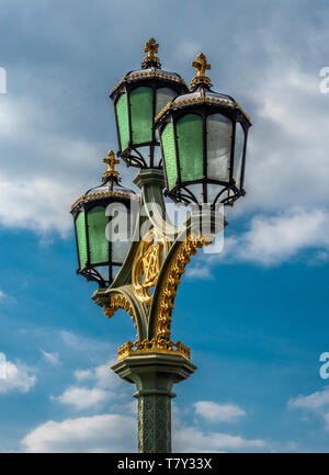 Triple standard lampe néo-gothique sur le pont de Westminster, Londres, Royaume-Uni. avec les initiales de la reine Victoria et le Prince Albert. Banque D'Images