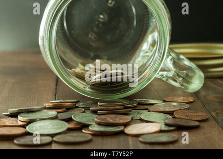 L'argent dans un bocal en verre sur la table en bois Banque D'Images