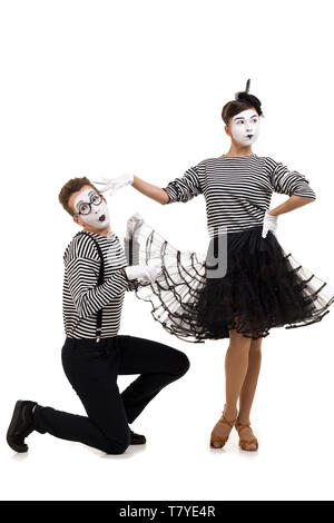 Smiling mimes en chemises à rayures. femme offensé et demande de pardon isolé sur fond blanc Banque D'Images