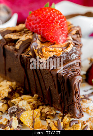 Tranche De Gateau Au Chocolat Avec Du Muesli Des Cereales Et Des Fraises Recouvertes De Bandes De Chocolat Noir Photo Stock Alamy