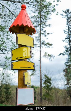 Vide conceptuel des signes de couleur jaune dans la forêt - bois ancien utilisé au toit rouge d'orientation Banque D'Images