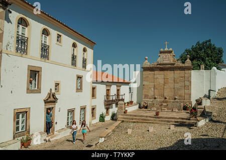 Les gens en face de vieille maison et fontaine en pierre de style baroque aux beaux jours à Marvao. Un hameau médiéval perché sur un rocher au Portugal. Banque D'Images