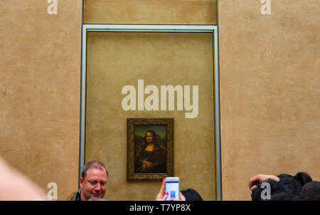 Les visiteurs du Musée du Louvre à prendre des photos de Leonardo da Vinci's Mona Lisa peinture avec leurs caméras. La peinture est l'un des plus célèbre du monde Banque D'Images