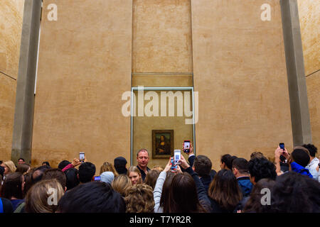 Les visiteurs du Musée du Louvre à prendre des photos de Leonardo da Vinci's Mona Lisa peinture avec leurs caméras. La peinture est l'un des plus célèbre du monde Banque D'Images