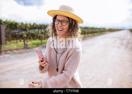 Femme prise d'une photo ou avec un chapeau selfies parmi la vigne dans la région de Bodega Septima Winery, Agrelo, Lujan de Cuyo, Mendoza, Argentine Banque D'Images