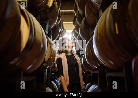 Femme de race blanche dans un milieu de barriques rangées dans Bodega Septima, Agrelo, Lujan de Cuyo, Mendoza, Argentine Banque D'Images