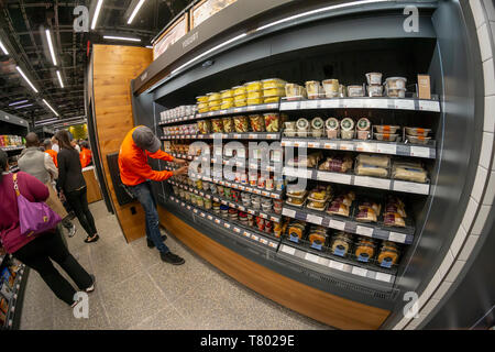 Les clients excités à la boutique Amazon Rendez-vous dans le magasin Brookfield Place Mall à New York le jour de son inauguration, le mardi 7 mai 2019. Les 1300 pieds carrés magasin, surtout approvisionné avec des aliments préparés et Staples, permet à un nouveau client avec l'Amazon Rendez-vous à l'app il suffit de prendre un élément et en tire des "Amazon" suivi de votre achat et vous facturer. Dans une torsion d'autres Amazon Rendez-magasins, celui-ci accepte l'argent comptant de plus, après avoir affronté la critique progressiste. (© Richard B. Levine) Banque D'Images