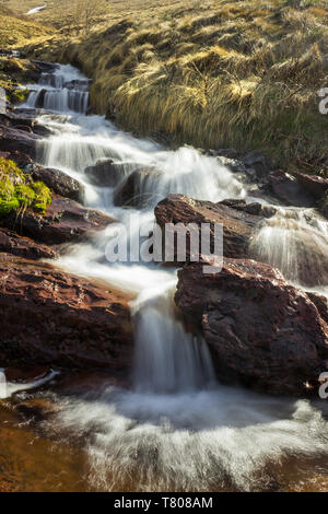 Vue rapprochée de la Moine pittoresque cascade saut sur vieille montagne en Serbie, avec l'herbe verte de plus en plus humide, la pierre rouge dans un avant-plan pendant le printemps Banque D'Images