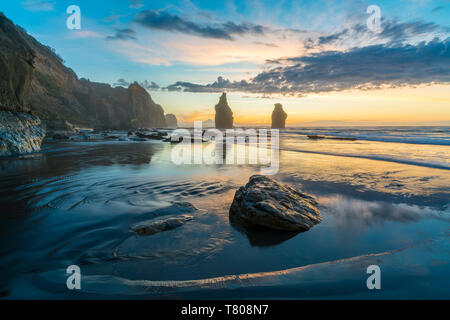 La réflexion des trois Sœurs à marée basse, au coucher du soleil, Tongaporutu, district de New Plymouth, Taranaki, région de l'Île du Nord, Nouvelle-Zélande, Pacifique Banque D'Images