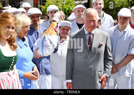 Glonn, Deutschland. 10 mai, 2019. Le Prince Charles et la duchesse Camilla posent avec des bouchers qui présente un grand jambon dans le Landwerkstaetten Herrmannsdorfer-une ferme biologique à Glonn (sud-est de Munich). Li : Sophie Schweisfurth. Visite du Prince de Galles et la duchesse de Cornouailles en Bavière les 10.05.2019. Utilisation dans le monde entier | Credit : dpa/Alamy Live News Banque D'Images