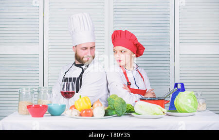 Bataille culinaire concept. Femme et homme barbu show culinaire concurrents. Qui mieux cuisiner. Cuisine ultime défi. Bataille de deux chefs culinaires. Couple en compétition en arts culinaires Cuisine règles. Banque D'Images