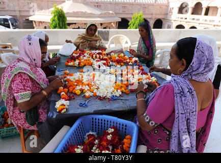 L'enfilage des femmes mala (guirlandes) pour Diwali puja dans le Temple Swaminarayan de marbre blanc orné, Bhuj, Gujarat, Inde, Asie Banque D'Images