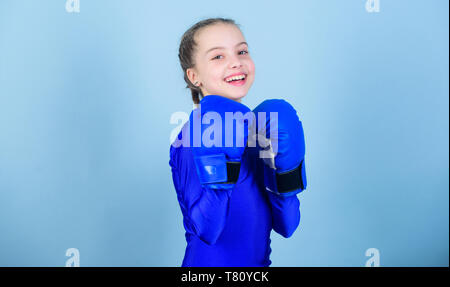 Heureux l'enfant sportsman dans des gants de boxe. Fitness diet. énergie santé. Séance d'entraînement de petite fille boxer perforatrice knock-out. L'activité de la petite enfance. Le succès de la mode sportswear Sport.. Le sport est notre vie. Banque D'Images