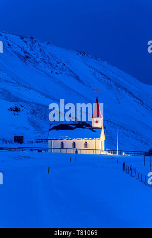 À l'aube de l'église illuminée contre montagnes couvertes de neige, hiver, près de Vik, le sud de l'Islande, Islande, régions polaires Banque D'Images