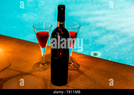 2 verres et bouteille de vin rouge au bord de la piscine, de la romance Banque D'Images