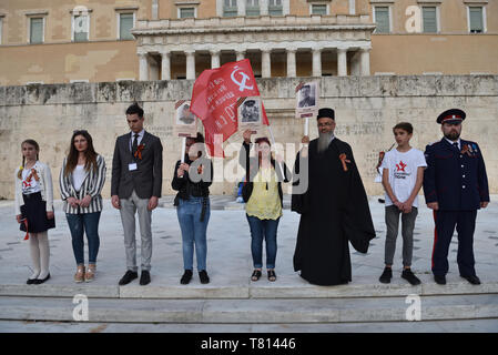 Athènes, Grèce. 9e mai 2019. Les participants se tiennent debout devant le monument du Soldat inconnu qu'ils prennent part à l'Immortel Regiment pendant la procession de la fête de la Victoire pour marquer le 74e anniversaire de la victoire sur l'Allemagne nazie et de commémorer le sacrifice de la Russie dans la deuxième guerre mondiale, à Athènes, Grèce. Crédit : Nicolas Koutsokostas/Alamy Stock Photo. Banque D'Images