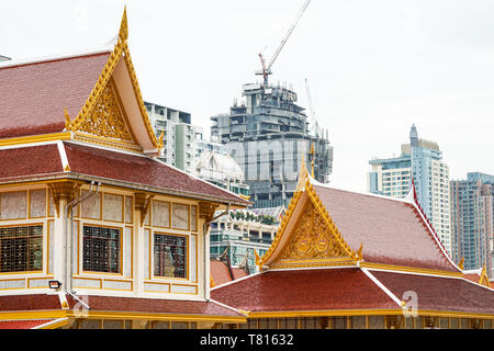 Temple thaï en face de construction urbaine. Représentant de la religion et de la civilisation urbaine, le bâtiment et la construction sont, à Bangkok, à fond. Banque D'Images