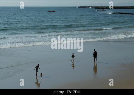 Deux garçons jouent au football avec le père sur la plage, entrée du port, Durban, KwaZulu-Natal, Afrique du Sud, les gens, le paysage, la ville, le soccer Banque D'Images