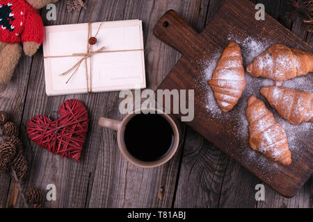 Cartes postales vieux papiers attachés avec une corde sur un fond de bois gris, vue du dessus, à côté d'une tasse de café Banque D'Images