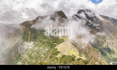 Vue aérienne du Wayna, Huayna Picchu pic à Machu Picchu des Incas et Machu Picchu complexe ville pic de montagne à travers à l'arrière-plan. Situé à Banque D'Images