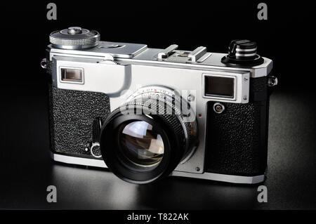 Ancien appareil photo télémétrique sur fond grainé noir Banque D'Images