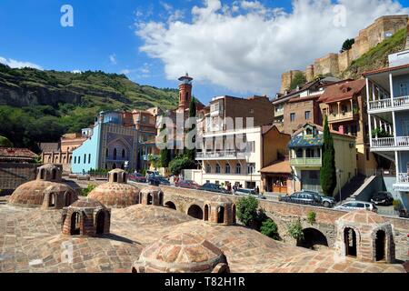 La Géorgie, Tbilissi, Vieille Ville, quartier thermal de Abanotoubani avec les toits des bains de soufre, le public des bains Orbeliani avec la façade carrelée bleu, le minaret de la mosquée et la forteresse de Narikala (4e siècle) à l'arrière-plan Banque D'Images