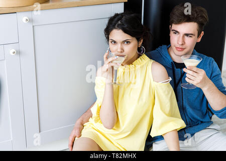 Jeune couple - un garçon et une fille, avoir du plaisir dans la cuisine, boire des cocktails. Accueil ambiance Banque D'Images