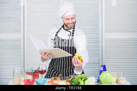 Livre des recettes de famille. Selon recette. Chef barbu homme à la cuisson des aliments. Guy lire livre de recettes. Concept d'arts culinaires. Apprendre l'homme recette. Améliorer les compétences de cuisson. Guide de cuisson ultime pour les débutants. Banque D'Images