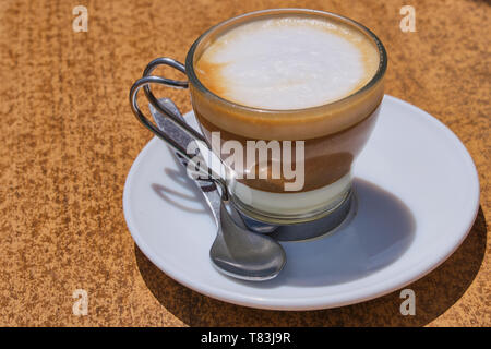 Café espagnol dans les îles Canaries avec lait concentré sucré sur une table marron Banque D'Images