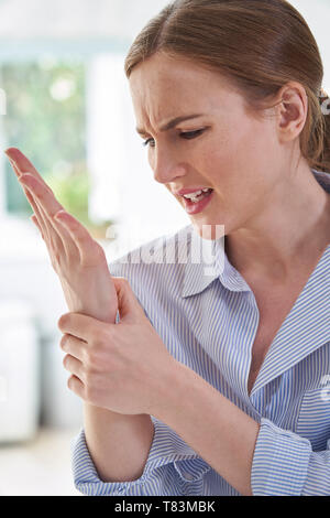 Femme dans la douleur du poignet Holding souffrant de microtraumatismes répétés Banque D'Images