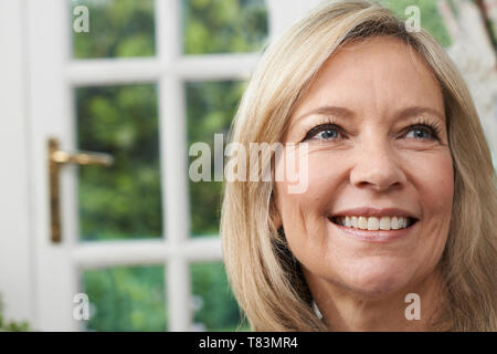 Head and shoulders Portrait Of Smiling Mature Woman at Home Banque D'Images