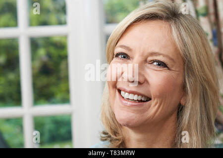 Portrait de la tête et des épaules Portrait Of Smiling Mature Woman at Home Banque D'Images