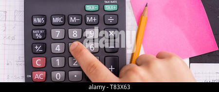 Doigt sur le bouton calculatrice mathématique au cours de leçon. Concept de l'école. Banque D'Images