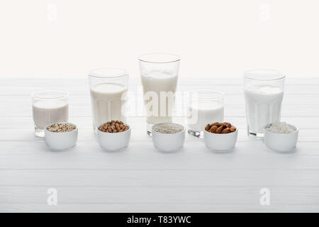 Lunettes avec coconut, le pois chiche, l'avoine, le riz et le lait d'amande avec les ingrédients dans des bols isolated on white Banque D'Images