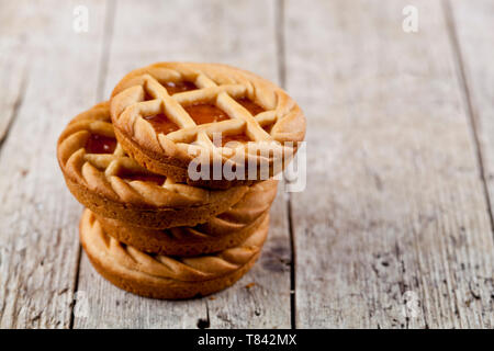 Tartes fraîchement cuit au four avec de la marmelade ou confiture d'abricot sur le fond de la table en bois rustique. Avec l'exemplaire de l'espace. Banque D'Images