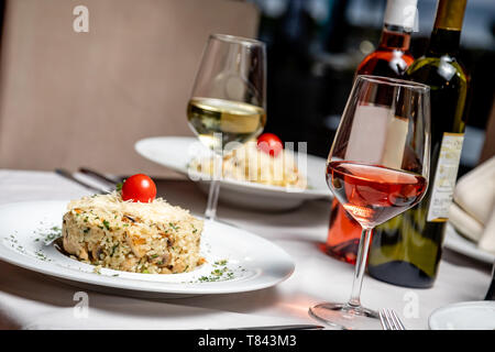 Risotto avec verre de vin blanc servi à table au restaurant Banque D'Images