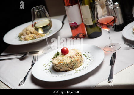 Risotto avec verre de vin blanc servi à table au restaurant Banque D'Images