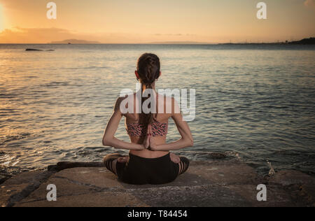 Woman practicing yoga at seaside Banque D'Images