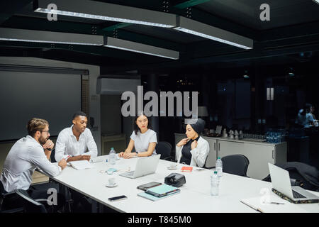 Les hommes et les femmes d'avoir table de conférence Banque D'Images