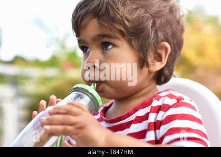 Boy drinking from le flacon en verre Banque D'Images