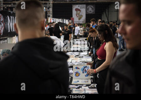 Athènes, Grèce. 10 mai, 2019. Les gens ont vu marcher et regarder les tatoueurs font leur travail pendant le festival.Des milliers d'artistes tatoueurs du monde entier ont pris part au cours de la 13e Convention Internationale de tatouages d'Athènes et ils ont aussi fait de tatouages des gens qui étaient intéressés. Credit : Nikolas Joao/Kokovlis SOPA Images/ZUMA/Alamy Fil Live News Banque D'Images