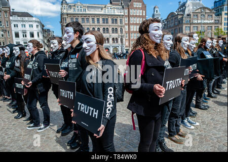 Amsterdam, Pays-Bas. 111e mai 2019. Les activistes végétaliens vu portant des masques de Guy Fawkes tout en tenant des pancartes lors de la manifestation. Des centaines de militants se sont réunis à la place du Dam, dans le centre d'Amsterdam à participer dans le Cube de la vérité. Pour les sans-voix anonyme l'hôte d'une réception ouverte 24h Cube de la vérité sur la place du Dam, à Amsterdam. Le Cube de la vérité est une manifestation statique pacifique similaire à un art performance. Cette démonstration fonctionne de manière structurée qui déclenche la curiosité et l'intérêt du public ; les militants tentent d'entraîner les personnes se trouvant à proximité d'un végétalien conclusion grâce à un combi Banque D'Images