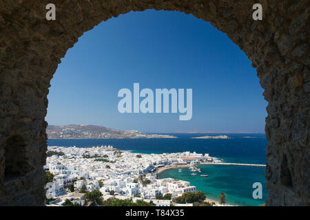 La ville de Mykonos, Mykonos, sud de la mer Egée, en Grèce. Vue sur la ville et le port par une voûte en pierre dans les remparts du château. Banque D'Images