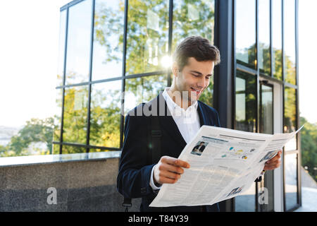 Business Man reading newspaper debout à l'extérieur Banque D'Images