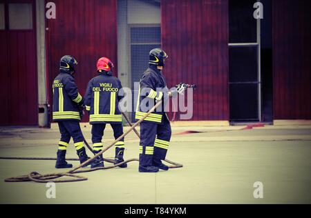 Italia, IT, Italie - 10 mai 2018 : trois pompiers italiens à la caserne avec unifiorm et texte Vigili del fuoco signifie que les pompiers en italien Lang Banque D'Images