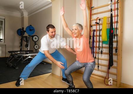 Senior woman doing squats Banque D'Images
