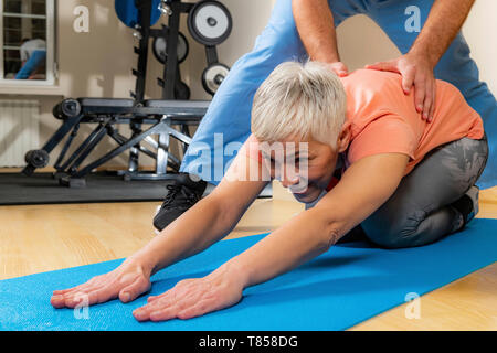 Physiothérapeute senior woman stretching Banque D'Images