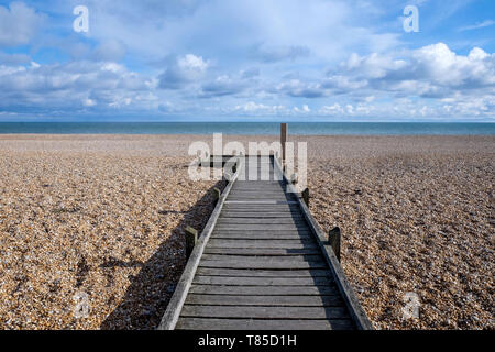 Une longue ligne droite decking en bois avec un diminshing point de vue sur une plage de galets, menant à la mer, le sentier commence au premier plan grande Banque D'Images