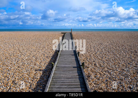 Une longue ligne droite decking en bois avec un diminshing point de vue sur une plage de galets, le chemin commence à l'avant-plan grand centre de l'image Banque D'Images