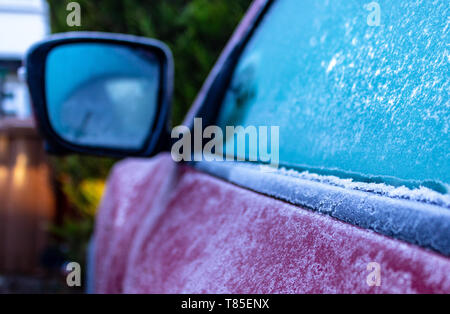 Voiture mauve couvert de givre sur un hiver très froid matin avant de racler la glace au large les fenêtres et aller au travail dans la profondeur de l'hiver. Banque D'Images